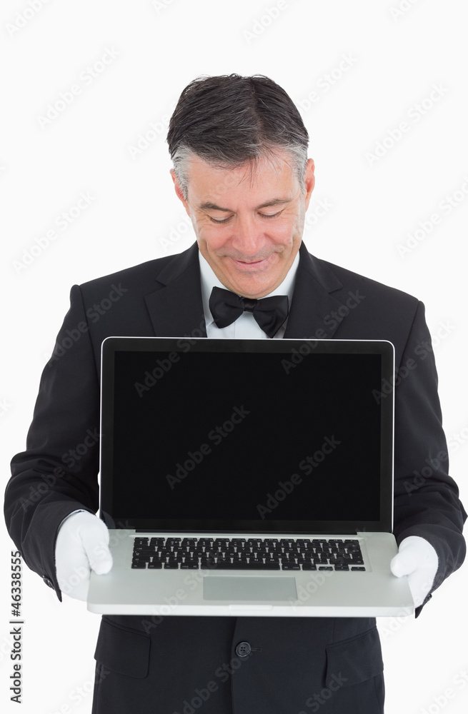 Happy waiter showing us something on a laptop Happy waiter showing us something on a laptop