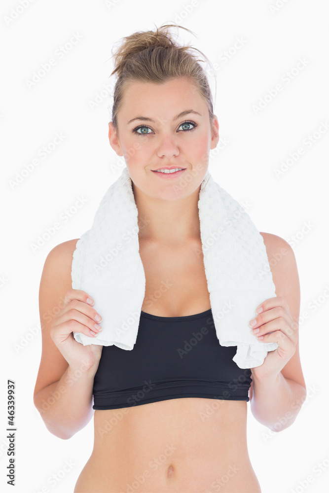 Woman standing while holding a white towel in sportswear Woman standing while holding a white towel in sportswear