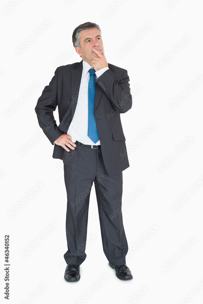 Businessman thinking with one hand on hip Businessman thinking with one hand on hip