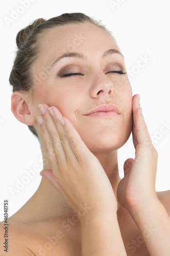 Blonde woman touching her face