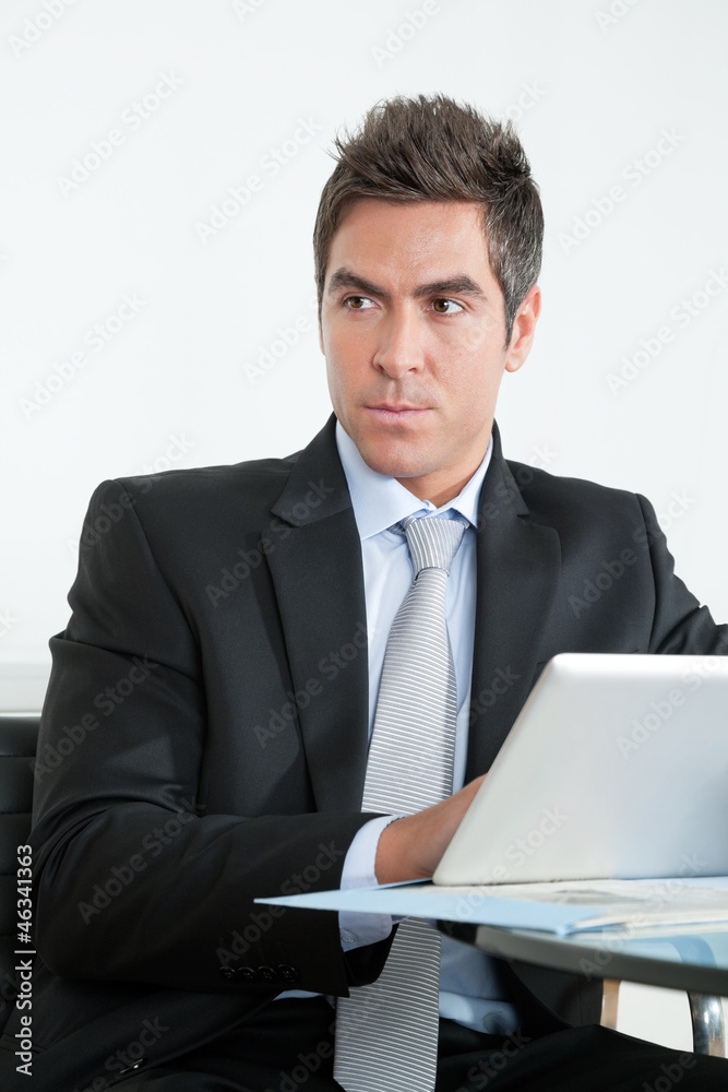 Young Businessman Using Digital Tablet In Office Young Businessman Using Digital Tablet In Office