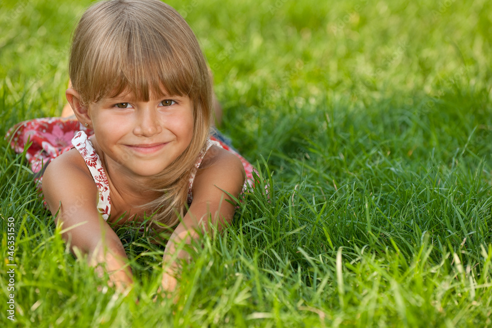 Joyful little girl on the grass