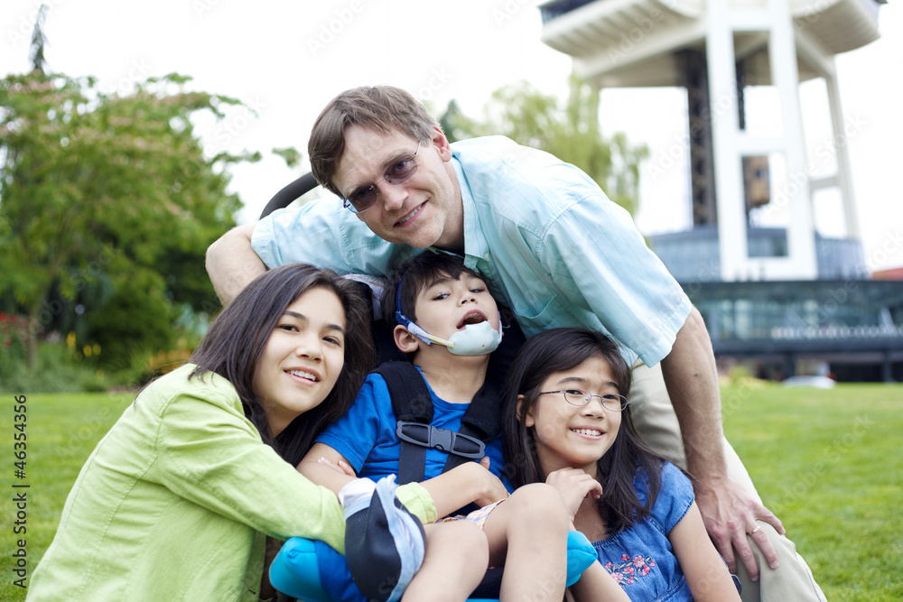 Disabled boy in wheelchair surrounded by family Disabled boy in wheelchair surrounded by family
