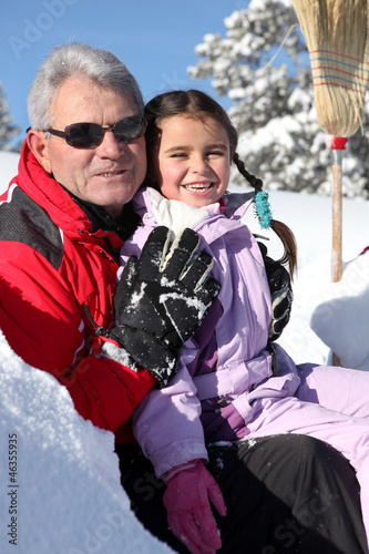 Grandfather and little girl in ski holidays