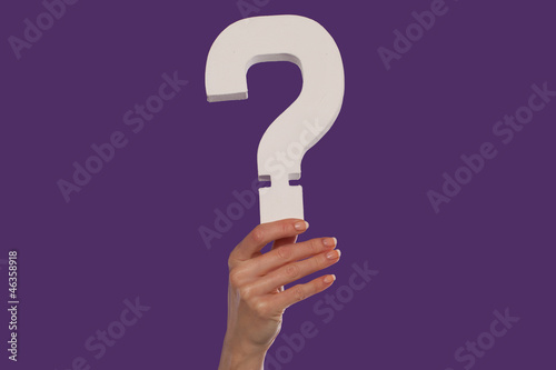 Female hand holding up a question mark from the bottom