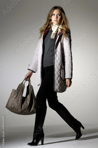 High fashion model with bag posing in the studio