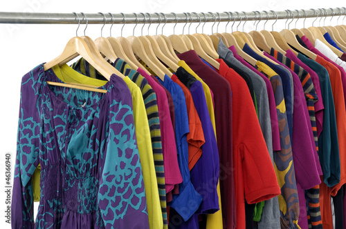 casual clothes of different colors on hangers
