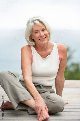 Old lady sat on wooden walkway