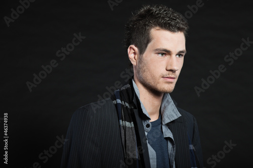 Handsome man dark winter fashion. Studio shot. Wearing scarf.