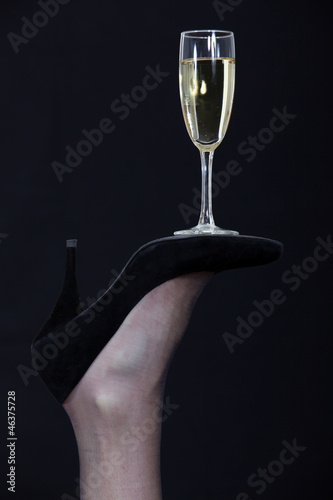 A champagne glass balanced on the sole of a shoe