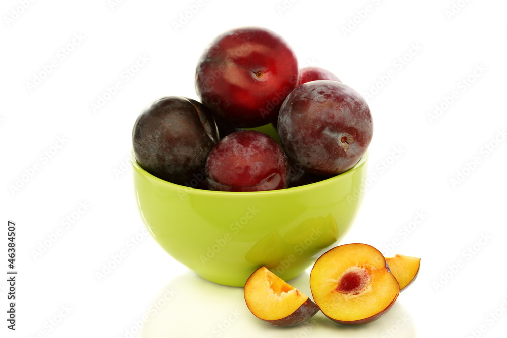 Red plums in green bowl. Red plums in green bowl.