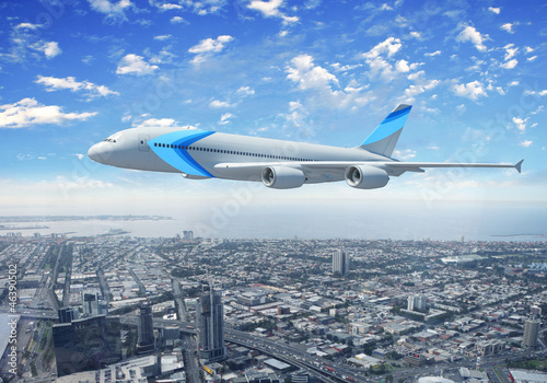 White passenger plane flying above a city