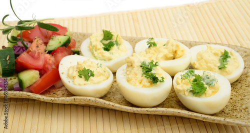 Deviled eggs with tomato, cucumber, onions and herbs