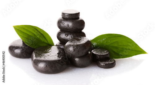 Spa stones with drops and green leaves isolated on white