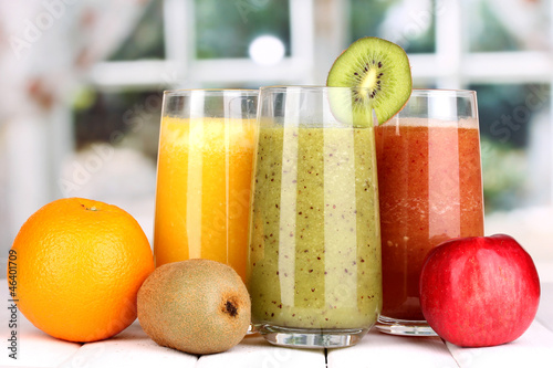 fresh fruit juices on wooden table, on window background