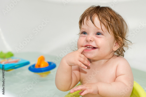 Portrait of cheery cute baby girl in a bath