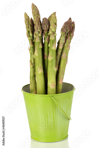 Fresh asparagus in green pail isolated on white.