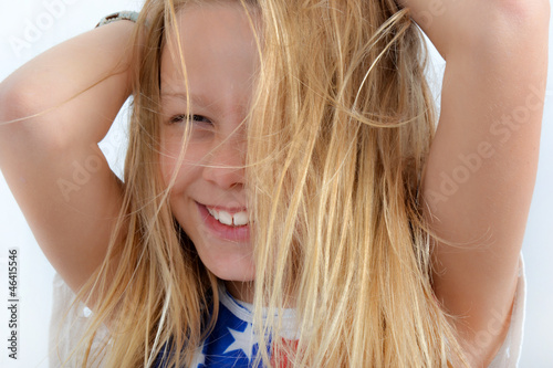 Blondinette riant cheveux sur la figure