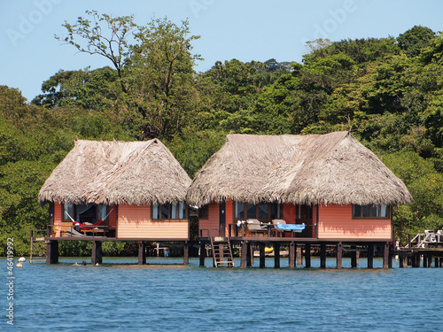 Tropical bungalows over water with thatched roof, Caribbean sea, Bocas del Toro, Panama, Central America