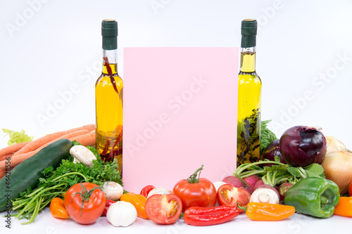 Fototapeta Naklejka Na Ścianę i Meble -  Pink paper for recipes between olive oil bottles and vegetable