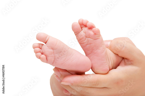 Newborn tiny baby feet in mother's hand isolated on white