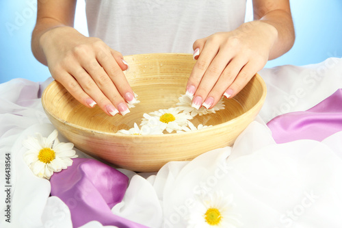 Fototapeta Naklejka Na Ścianę i Meble -  woman hands with wooden bowl of water with flowers,