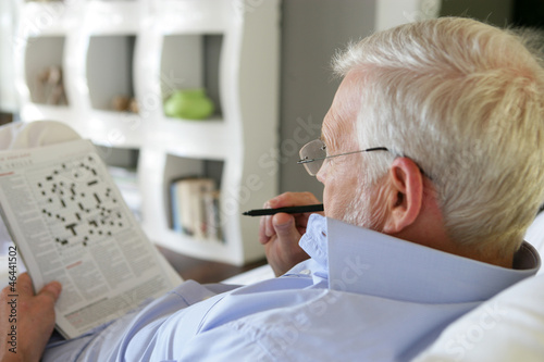 Senior man doing crossword photo