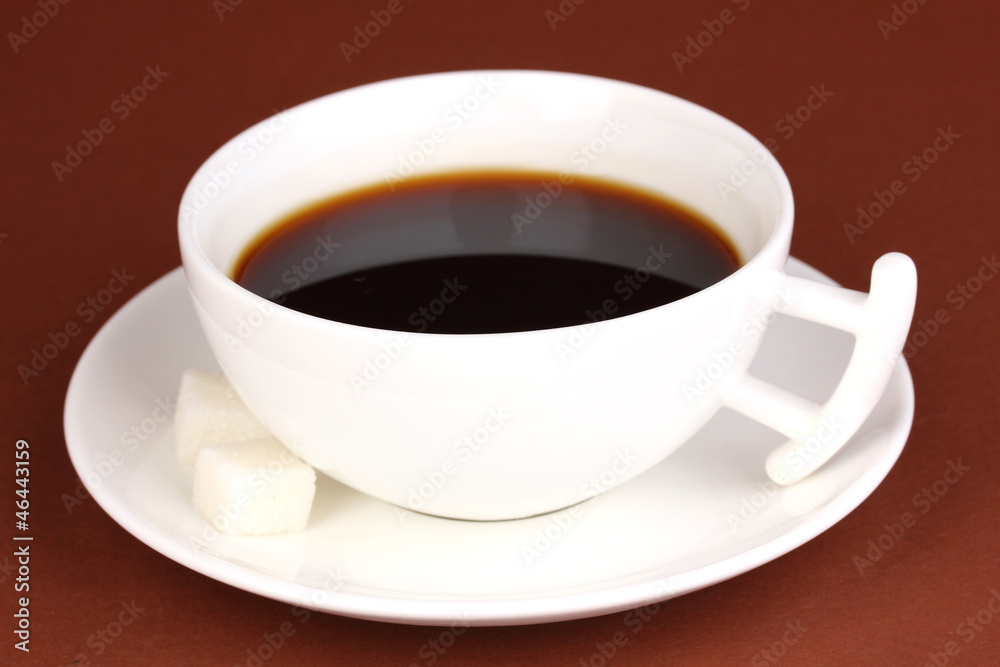 A cup of strong coffee on brown background