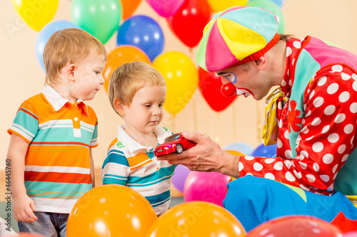 clown making present child boy on birthday party