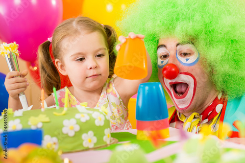 child girl playing with clown on birthday party