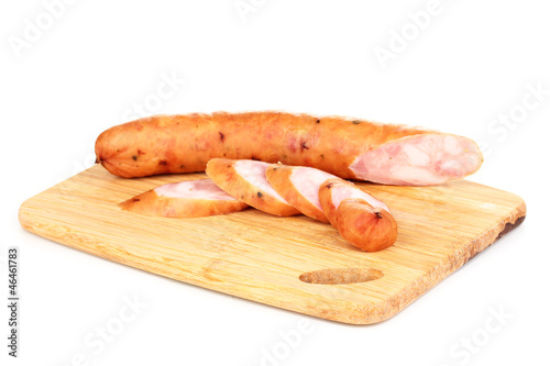 Tasty sausage on chopping board isolated on white