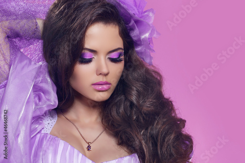 Beautiful woman with curly hair and bright make-up. Jewelry and