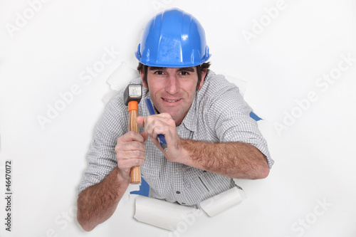 Man with hammer and nail tearing through photo