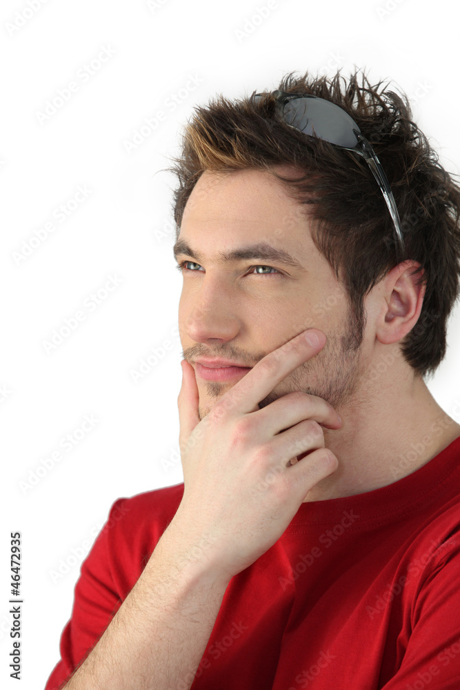 Pensive young man with sunglasses resting on his head Pensive young man with sunglasses resting on his head