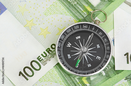 euro bank notes and a compass