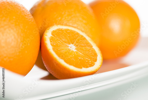 Close up of fresh oranges on plate.