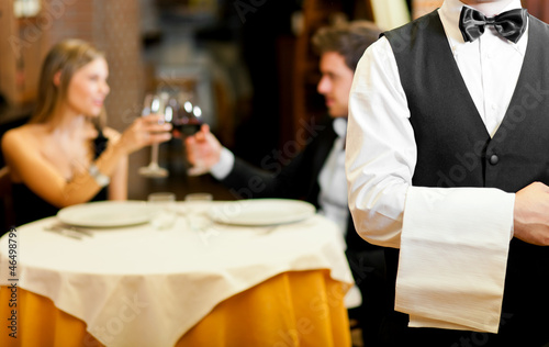 Couple at restaurant: focus on waiter