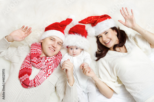 Christmas family in red hats. Hapy parents and baby