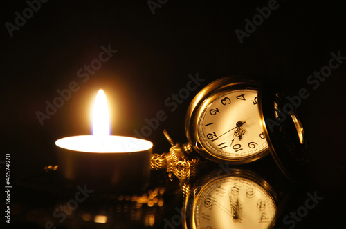 Vintage pocket watch, with burning candle