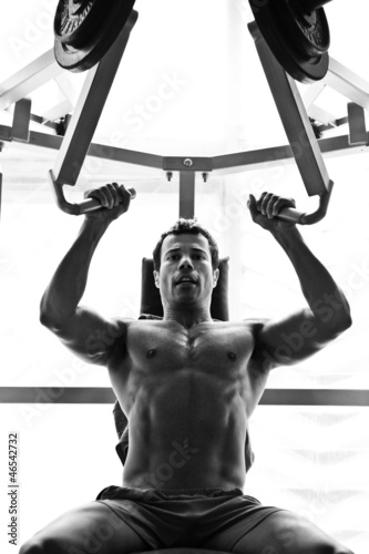 bodybuilder hard taining in the gym: shoulder press photo