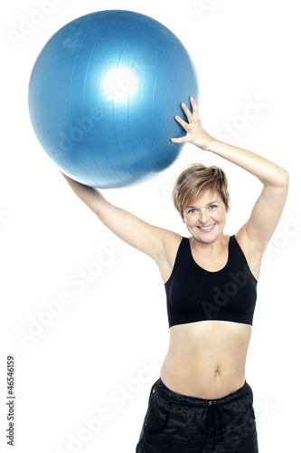 A healthy woman lifting big swiss ball