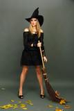 Halloween witch with  broom on gray background