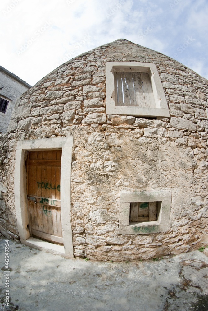 Old abandoned stone house in front view