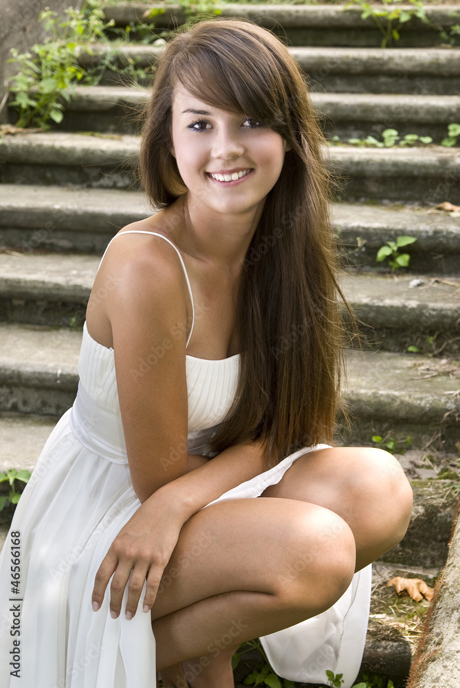 Naklejka premium Pretty happy young brunette posing outdoors .