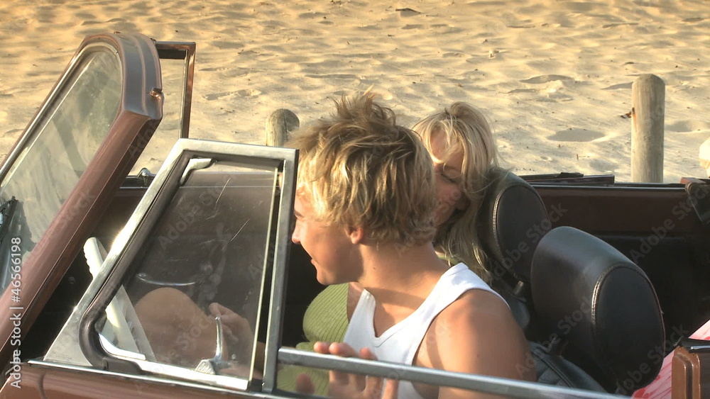 MS OF A YOUNG MAN GETTING OUT OF A CAR AND KISSING A YOUNG WOMAN