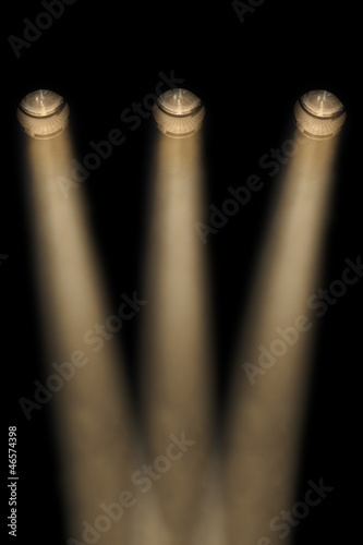 Three yellow spotlights in a smoky atmosphere
