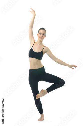 fit brunette in black sportswear practicing yoga over white