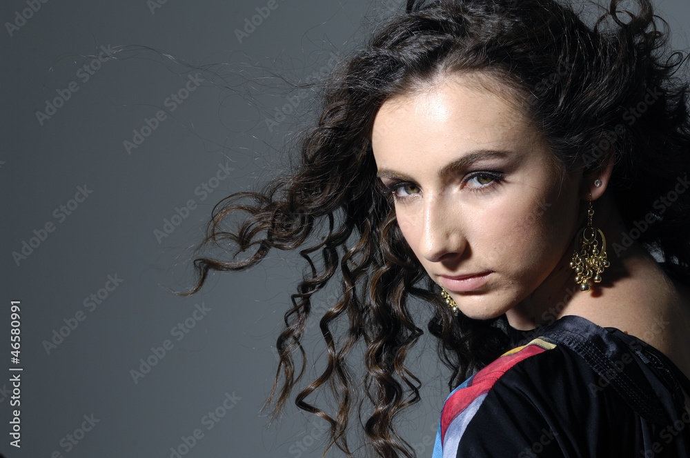 pretty sexy woman with long curly hair on gray background pretty sexy woman with long curly hair on gray background