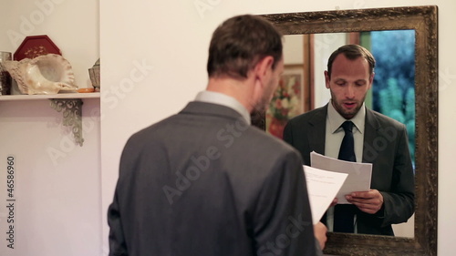 Young businessman practice his speech in front of mirror 