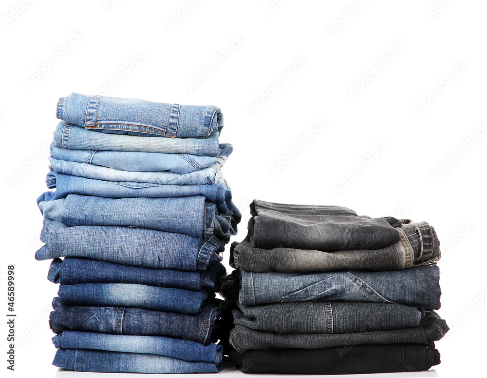 Many jeans stacked in a piles isolated on white Many jeans stacked in a piles isolated on white